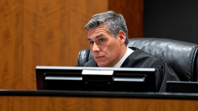 Judge Tony Graf seated behind a courtroom monitor in Provo, Utah