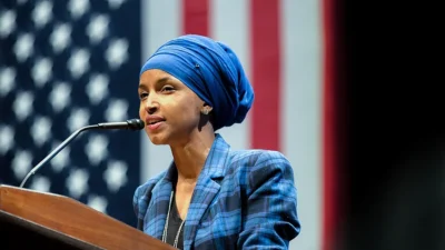 Ilhan Omar speaks at a podium at the University of Minnesota.