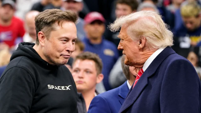 Elon Musk talks with President Donald Trump at a crowded event